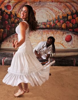 Happy dancing woman with handsome drummer indoors