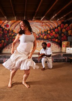 Happy Brazillian dancer and pandeiro performing indoors