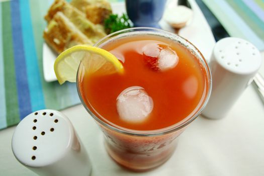 Fresh tomato juice on ice with a slice of lemon.