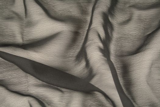 Background of crumpled textile providing textures and shadows.