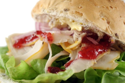 Turkey and lettuce with red onions and cranberry sauce on a wholemeal roll.