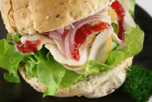 Turkey and lettuce with red onions and cranberry sauce on a wholemeal roll.