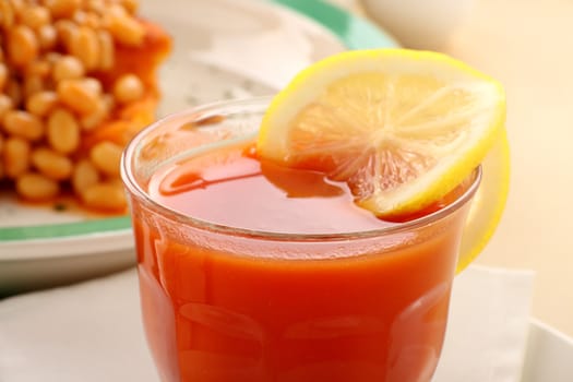 Refreshing tomato juice and lemon with baked beans for breakfast.