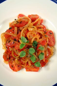 Warm salad consisting of cherry tomatoes and caramelized onion with oregano. 