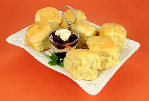 Fresh Baked scones with jam and cream on a tray ready to serve.