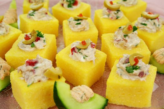 Tuna filled polenta squares with cream cheese, olives and parsley.