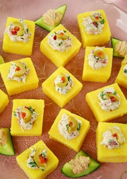 Tuna filled polenta squares with cream cheese, olives and parsley.