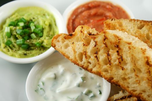 Delicious and colorful trio of dips with grilled Turkish bread.