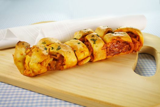 Twisted savory bread loaf with cheese, ham, pineapple and tomato filling.