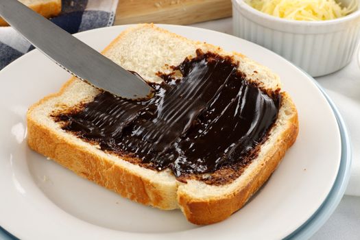 Spreading the iconic Australian spread vegemite on to a slice of fresh bread.