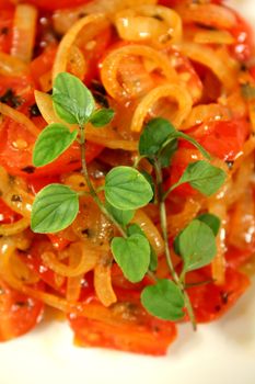 Warm salad consisting of cherry tomatoes and caramelized onion with oregano. 