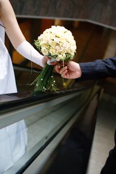 wedding bouquet in hands of the bride and groom