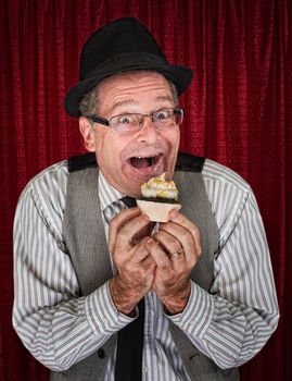Happy retro style man holding a cupcake
