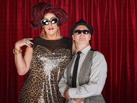 Tall drag queen and retro style man in sunglasses