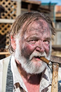 Old West Blacksmith Smokes Cigar While Holding Mallet