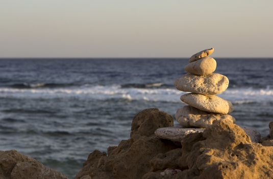 several stones stacked on a rock by the sea