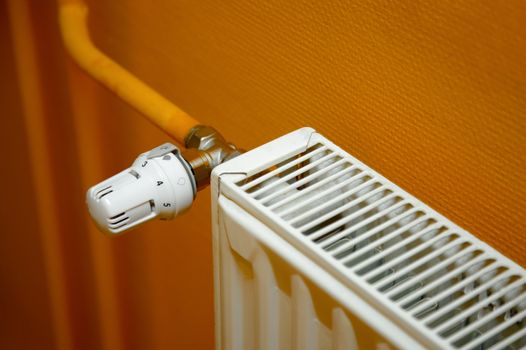 Heating radiator detail against orange wall