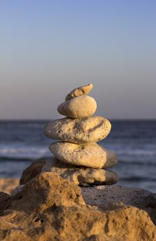 several stones stacked on a rock by the sea