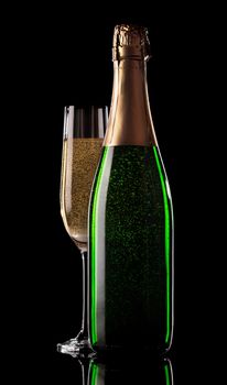 Glass and bottle of champagne on a black background