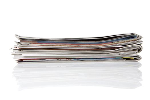 several newspapers, journals stacked on white background