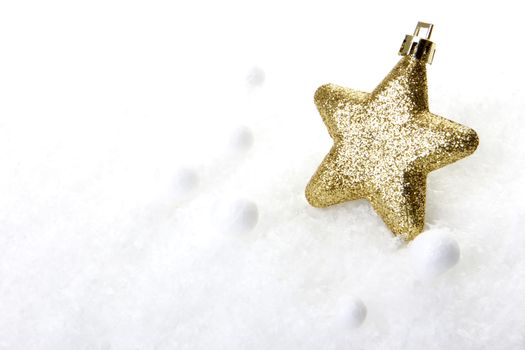 gold christmas bauble as christmas star on snow