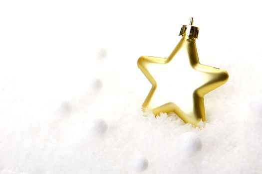 gold christmas bauble as christmas star on snow