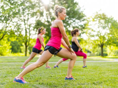 Portrait of three women streching their legs before jogging together