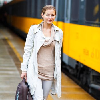 Pretty young woman at a train station (color toned image)