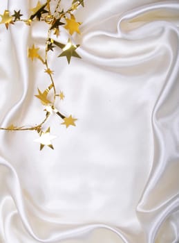 Golden stars and spangles on white silk as background