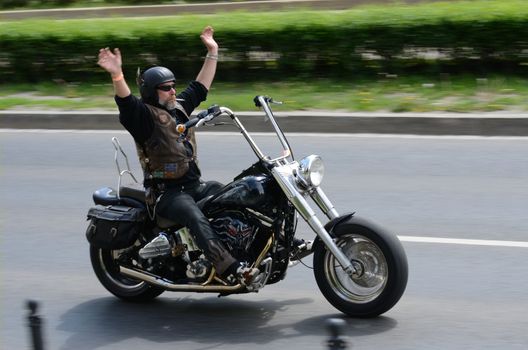 WROCLAW, POLAND - MAY 18: Unidentified motorcyclist rides Harley-Davidson and greets spectators during parade. Around 8 thousands riders joined Super Rally  from 16 to 20 May 2013 in Wroclaw.