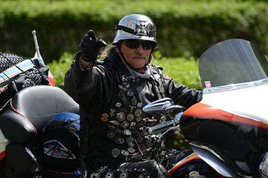 WROCLAW, POLAND - MAY 18: Unidentified motorcyclist rides Harley-Davidson and greets spectators. Around 8 thousands riders joined Super Rally  from 16 to 20 May 2013 in Wroclaw.