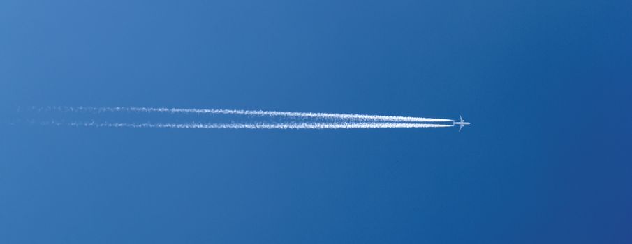 aircraft in a clear blue sky with condensation trail