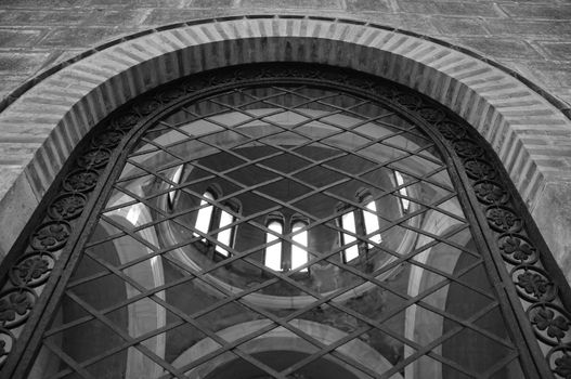 Arched window antique ironwork pattern and mausoleum dome. Black and white.