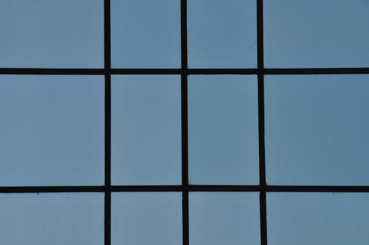 Straignt black lines and blue rectangular windows. Modern facade abstract detail.