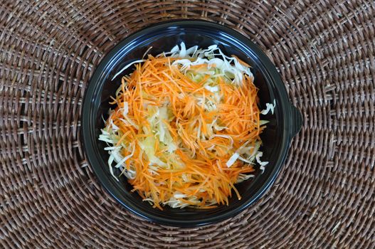 Bowl of cabbage and carrot fresh vegetables salad. Food background.
