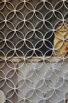 Rusty metal door with geometric circles motif and paint stained glass background.