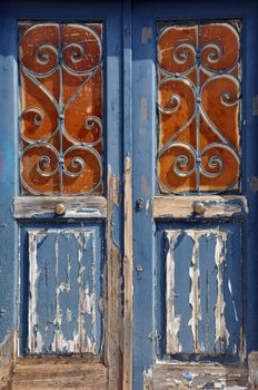 Old wooden door with vintage metal frame pattern and chipped paint texture.
