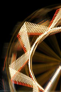 Ferris wheel at night. Abstract blurry shapes amusement park lights in motion.