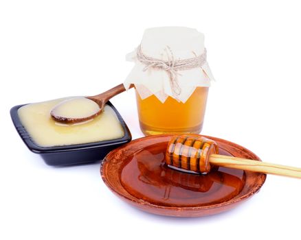 Arrangement of Wooden Dipper with Honey into Brown Plate, Glass Jar with Flower Honey and White Honey Black Bowl with Wooden Spoon isolated on white background