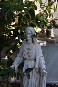 Jesus Christ marble funerary statue among leaves.