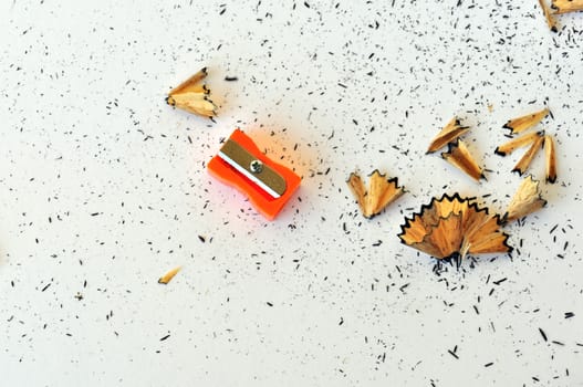 Pencil sharpener and shavings on white backgound.