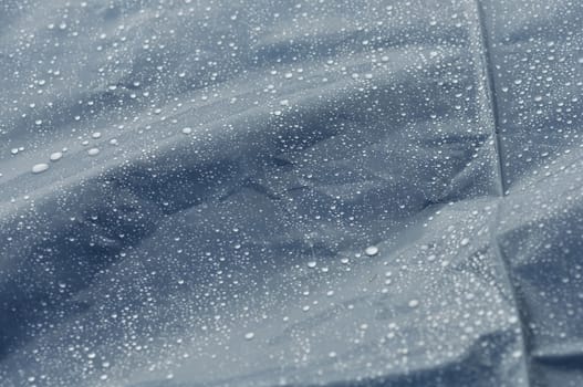 Rain drops on bumpy plastic surface abstract autumn weather macro background. Selective focus.