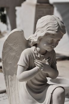 Praying angel marble funerary statue. Mourning cherub abstract.