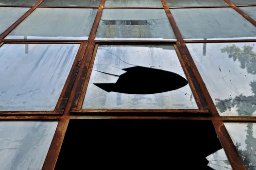 Smashed rusty windows of a decayed building. Abstract grunge background.