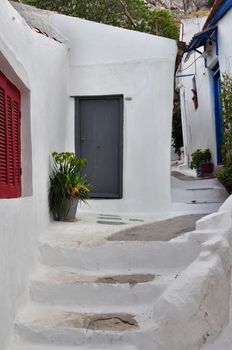 Steps, white painted narrow street and small houses in the traditional Anafiotika neighborhood of Plaka, Athens Greece.