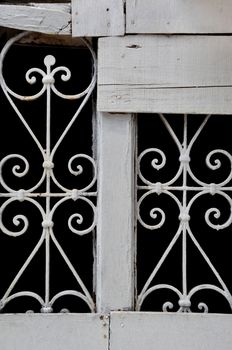 Vintage decorative metal pattern and grungy wood background with rusty nails.