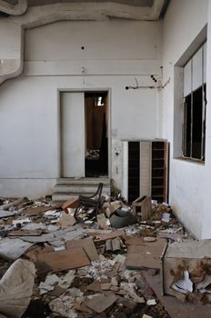 Vandalized room debris on the floor of abandoned building interior.