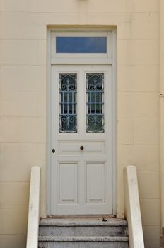 Steps and wooden door with vintage wrought iron pattern. Architectural detail.