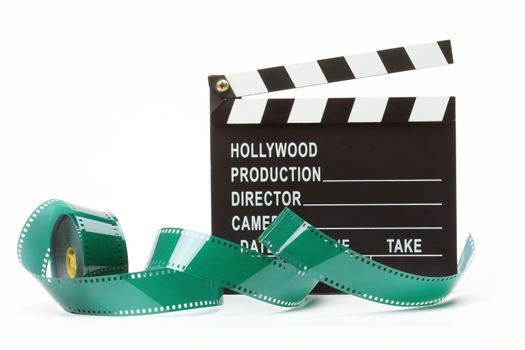 Movie clapper board and film roll over white