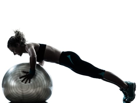 one caucasian woman exercising fitness ball workout posture in silhouette studio isolated on white background